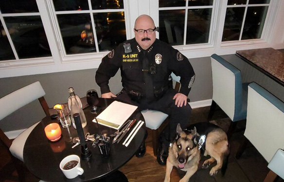 armed guard at table with dog
